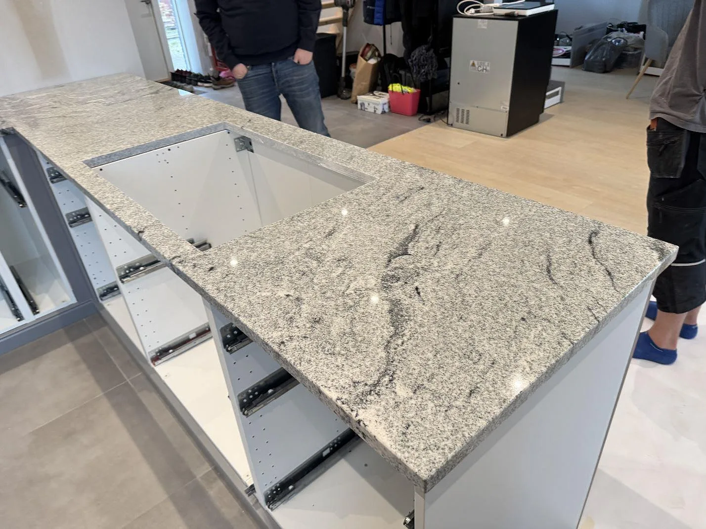 Köksö i polerad Viscont White granit med förberett urtag och synliga stommar i Kävlinge.