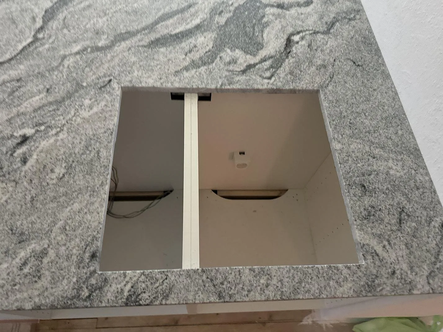 Polerad Viscont White-granit med rektangulärt urtag för häll i köksbänkskivan på vita stommar i Olofström.