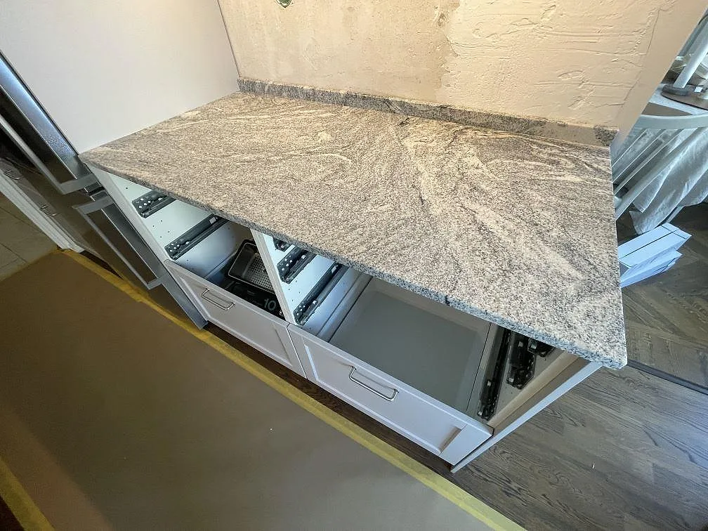 Närbild av polerad Viscont White granit som köksbänkskiva med grå ådring och låg stänkkant i Stockholm.