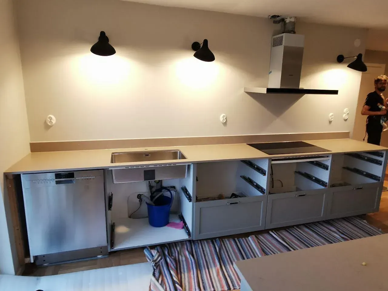 Köksbänkskiva i varm beige Silestone Coral Clay med nedsänkt diskho och induktionshäll, mot gråa luckor i ett kök i Vejbystrand.