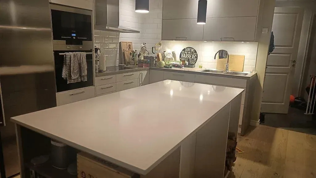 Köksö med bänkskiva i vit Silestone Eternal Statuario, polerad, tillverkad i ett enda stycke i ett kök i Varberg.